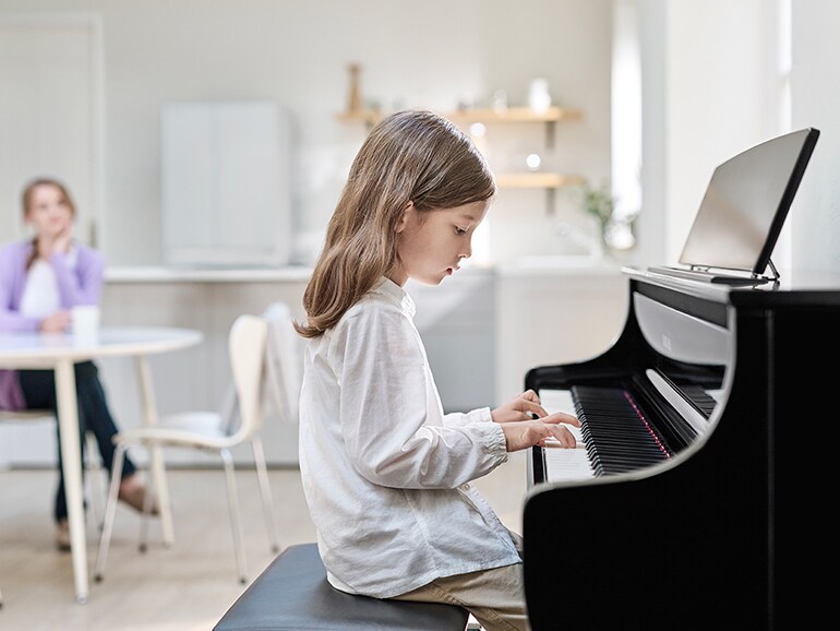 Child practising on a Yamaha Clavinova