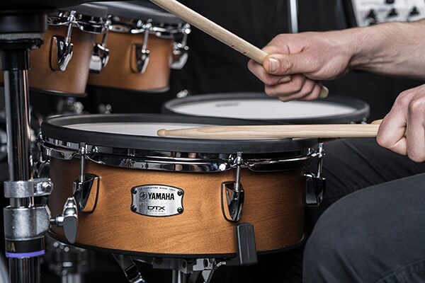 Drummer playing the birch-shell snare pad of a Yamaha DTX10 electronic drum kit